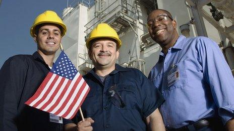 Men in hard hats hold an American flag