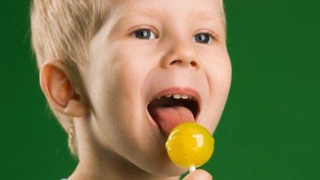 Boy licks lollipop