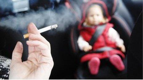 Smoking cigarette in a car with a small child in the back seat.