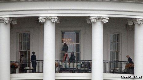 Law enforcement officials examine a White House window for damage