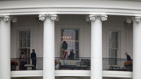 Law enforcement officials examine a White House window for damage