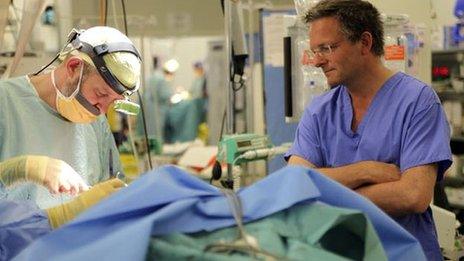 Plastic surgeon, Surgeon Commander Rory Rikkard operating on a patient in Camp Bastion field hospital in Afghanistan with Michael Mosley watching (right)