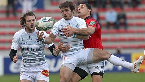 Marc Andreu of Castres is tackled by Munster's Dougie Howlett