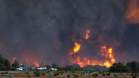 Residents of the Margaret River area of Western Australia watch a bushfire from the tops of their cars - 23 November 2011