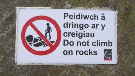 The warning signs on the rocks at Tywyn beach