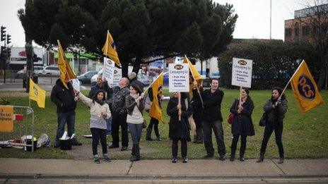 PCS (Public and Commercial Services) union members wave flags at cars near Heathrow Airport