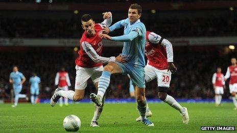 Manchester City's Edin Dzeko and Arsenal's Laurent Koscielny