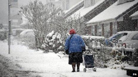 A woman drags a trolley through snow