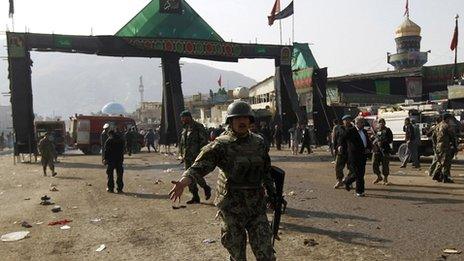 An Afghan National Army soldier disperses the crowd after a suicide attack at a Shia Muslim gathering in Kabul December 6, 2011.