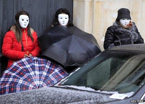 Prostitutes wearing masks rally outside the National Assembly in Paris, 6 December