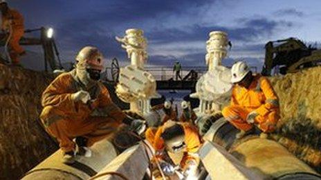 Workers in India at a pipeline