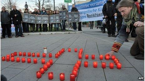 A man lights candles during a commemoration vigil for the victims of a murder series allegedly committed by a right-wing terror group, on November 28, 2011 in Erfurt, eastern Germany