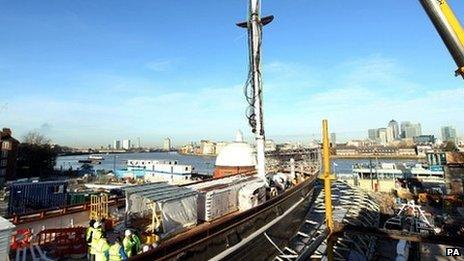 The foremast on the Cutty Sark is lowered by a crane