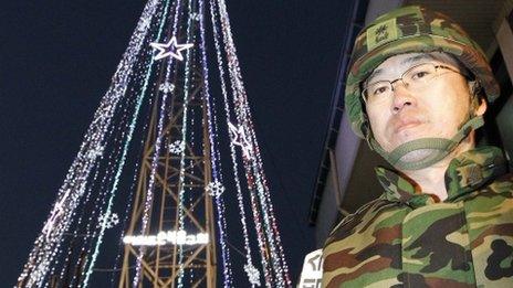 South Korean military officer stands guard as Christians prepare a lighting ceremony of a tree near the border with the North in December 2010