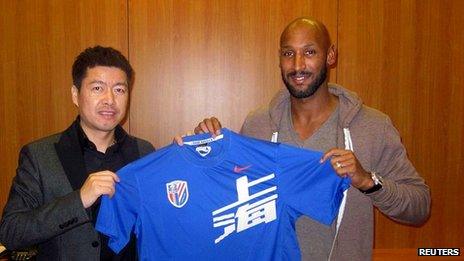 Anelka (r) poses with Shanghai Shenhua shirt