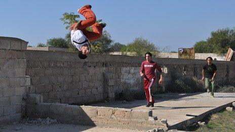 Mohammed Jamal Jahbir jumps in the air, followed by Abdullah Mamoun and Jihad Abu Sultan in Khan Younis