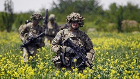 US Army soldiers walk through a field during a patrol near the village of Sami Kalache in the Arghandab Valley, north of Kandahar, 15 April 2011