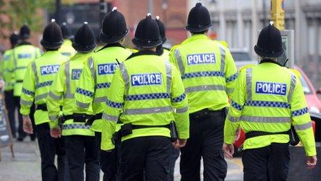 Police officers in high visibility jackets walking away from the camera