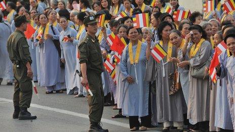 Vietnamese buddhist followers watch as monks exit a Vietnam Airlines aircraft at Hanoi's Noi Bai airport on March 3, 2010