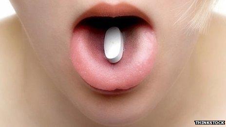 Pill on woman's tongue