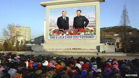 North Koreans bow in front of a statue showing Kim Il-sung and Kim Jong-il in Pyongyang on 19 December 2011