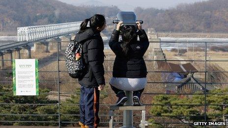 Tourists look across the demilitarised zone into North Korea on 20 December 2011