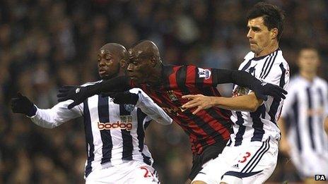 Paul Scharner (right) and Youssouf Mulumbu (left) battle for the ball with Manchester City's Mario Balotelli