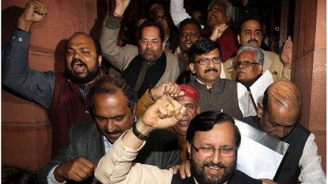 Indian Law makers from opposition parties shout slogans against ruling Congress party as they come out of parliament house after a debate on anti corruption bill in the Upper house, in New Delhi, India, Friday, Dec. 30, 2011