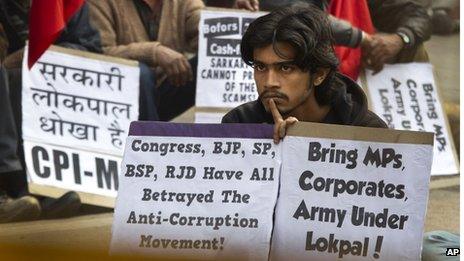 An activist of Communist Party of India (Marxist and Leninist) listens to a leader during a protest against the government's version of an anti-corruption bill in New Delhi, India, Thursday, Dec. 29, 2011