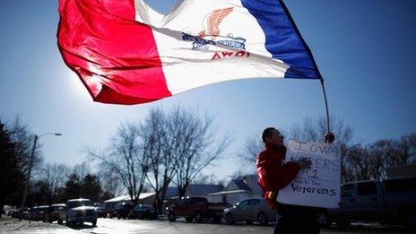 A man waves a state flag in Atlantic, Iowa, on 1 January 2012