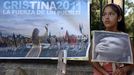 A girl holds a portrait of Argentine President Cristina Fernandez de Kirchner outside the Austral Hospital in Pilar, Buenos Aires, on 3 January 2012,