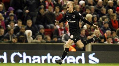 Robbie Simpson celebrates putting Oldham in front at Anfield