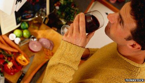 Man drinks wine while cooking