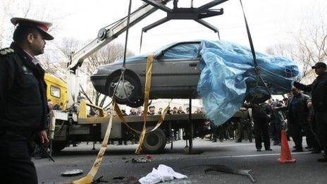 People gather around a car targeted in an apparent bomb attack in Tehran, Iran (image provided by semi-official Fars News Agency)