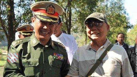 This picture taken on January 11, 2012 shows General Mutu Saipo (R), a representative of the rebel Karen National Union (KNU), shaking hands with a Burmese official upon his arrival for talks with a Burmese government delegation, in Hpa-An, the main city of the country"s eastern Karen state.