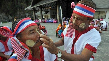 This picture taken on January 11, 2011 shows ethnic Karen men applying a traditional tanakha paste to each other as they prepare for a welcoming ceremony organised for leaders of the rebel Karen National Union arriving for talks with a Burmese government delegation