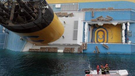 Italian firefighters scuba divers approach the cruise ship Costa Concordia