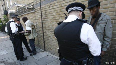 Two men speaking to police officers