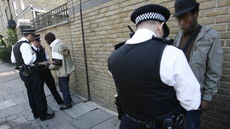 Two men speaking to police officers