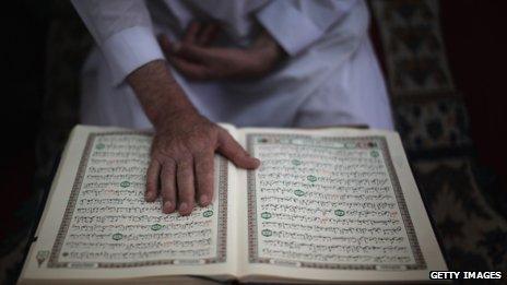 A mourner reads the Koran