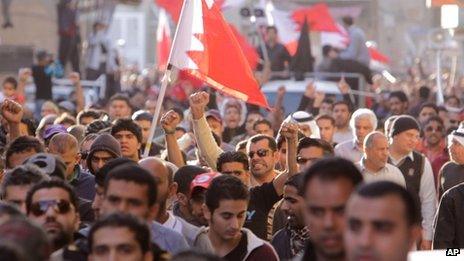 Mourners at a funeral for an anti-government protester wave Bahraini flags and chant anti-government slogans (15 January 2012)