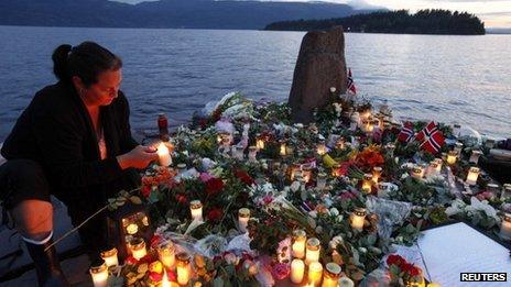 Woman lights candle to victims of Anders Behring Breivik on the shore opposite Utoeya island, Norway - 26 July 2012