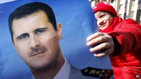A pro-Syrian regime protester holds a portrait of Syrian President Bashar Assad in Damascus, Syria, on 20 January 2012
