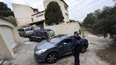 A policeman stands outside Mr Mas's home