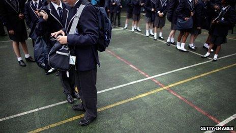 Pupils wait in a playground