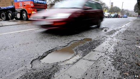 Car driving past pothole