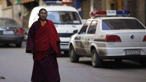 An ethnic Tibetan monk walks past a police station in Danba, Sichuan province on 26 January 2012