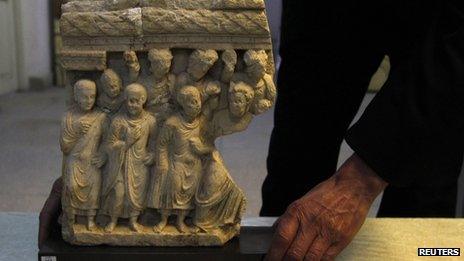 An Afghan specialist displays the ancient pre-Islamic sculpture returned by Germany