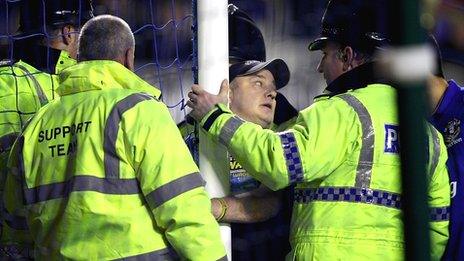 A spectator handcuffs himself to a goalpost during Everton's match with Manchester City at Goodison Park