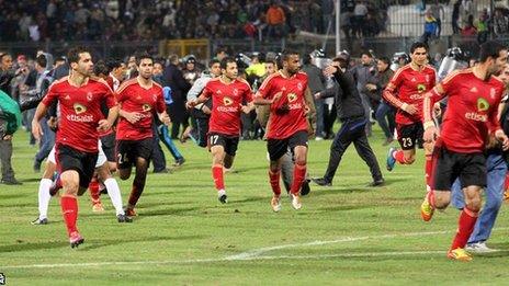 Al-Ahly players flee the pitch at the end of the game against al-Masry